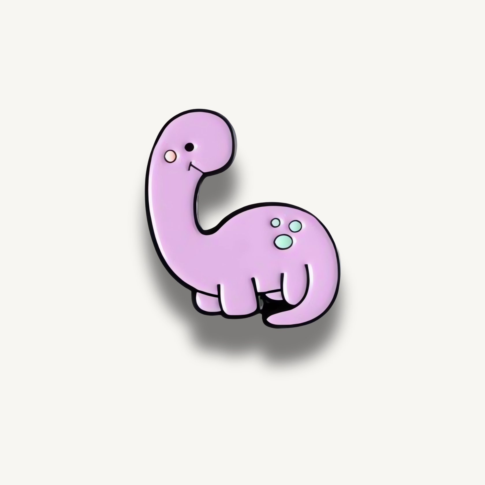 Smaltovaná brošňa s fialovým dinosaurom a bledomodrými bodkami.