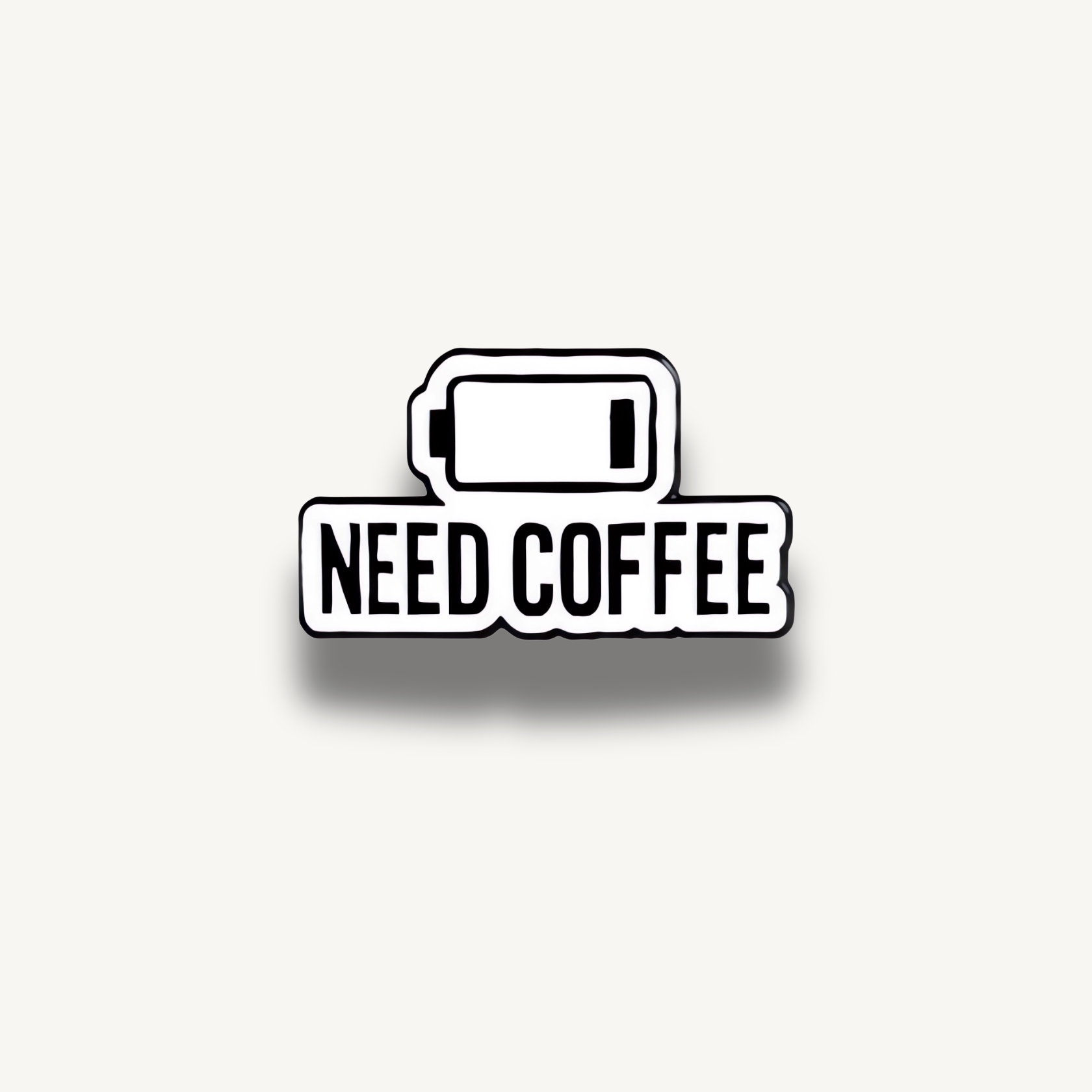 Smaltovaná brošňa s ikonou vybitej batérie a nápisom 'NEED COFFEE'.