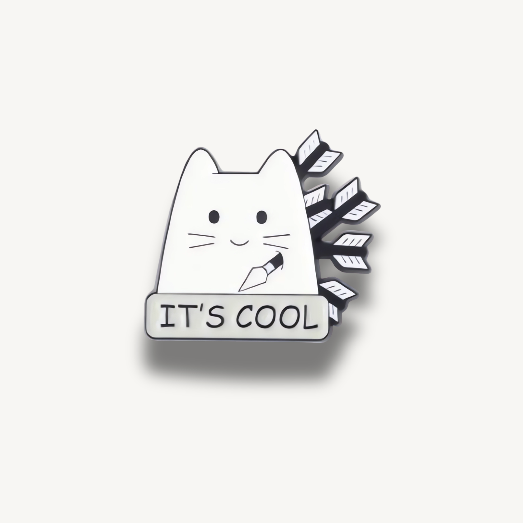 Smaltovaná brošňa bielej mačky s nožom v ústach, čiernymi šípmi za chrbtom a bielym nápisom 'IT'S COOL'.
