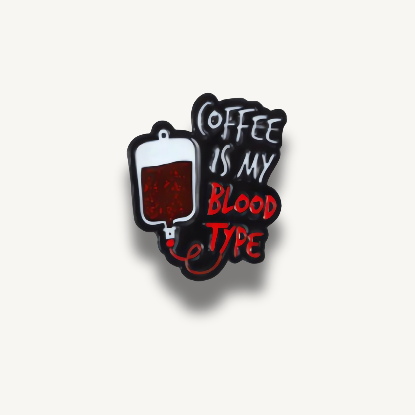 Čierna smaltovaná brošňa s bielou infúziou kávy a bielym a červeným textom COFFEE IS MY BLOOD TYPE.