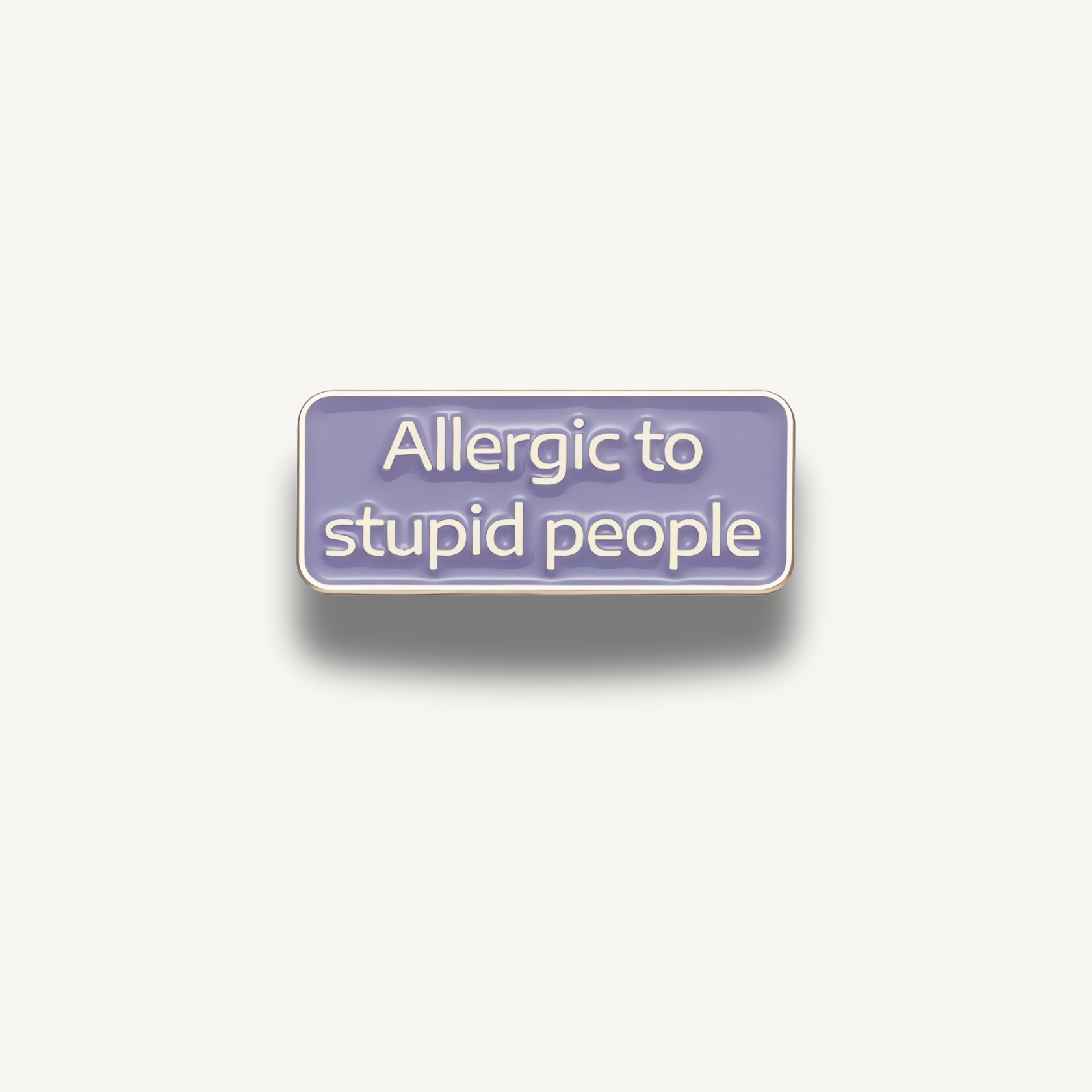 Fialová smaltovaná brošňa s bielym nápisom 'Allergic to stupid people' na obdĺžnikovom tvare.