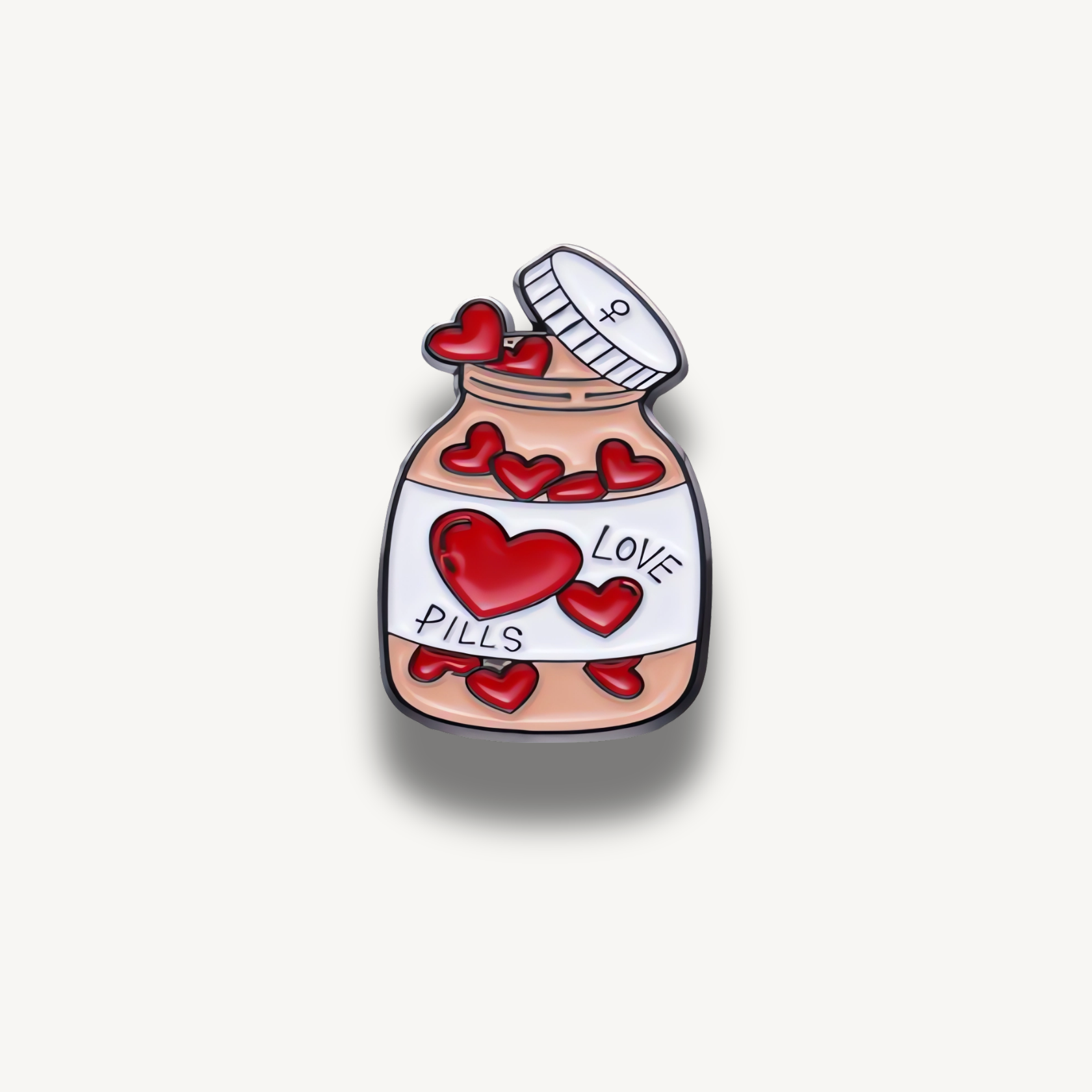 Smaltovaná brošňa fľaša plná červených srdiečok s bielym nápisom LOVE PILLS a otvoreným viečkom.