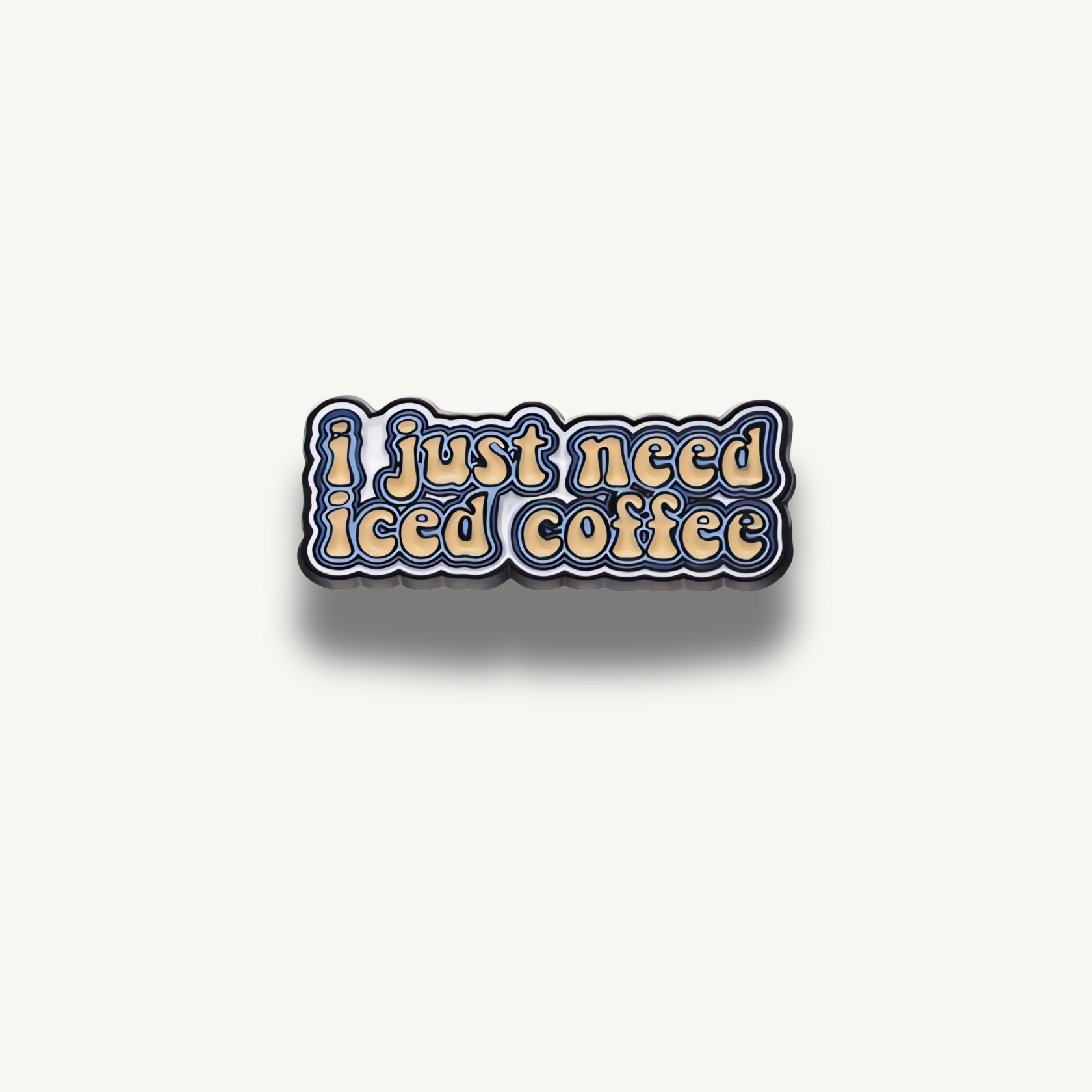 Smaltovaná brošňa s textom 'i just need iced coffee' v žltej farbe s modrými okrajmi.