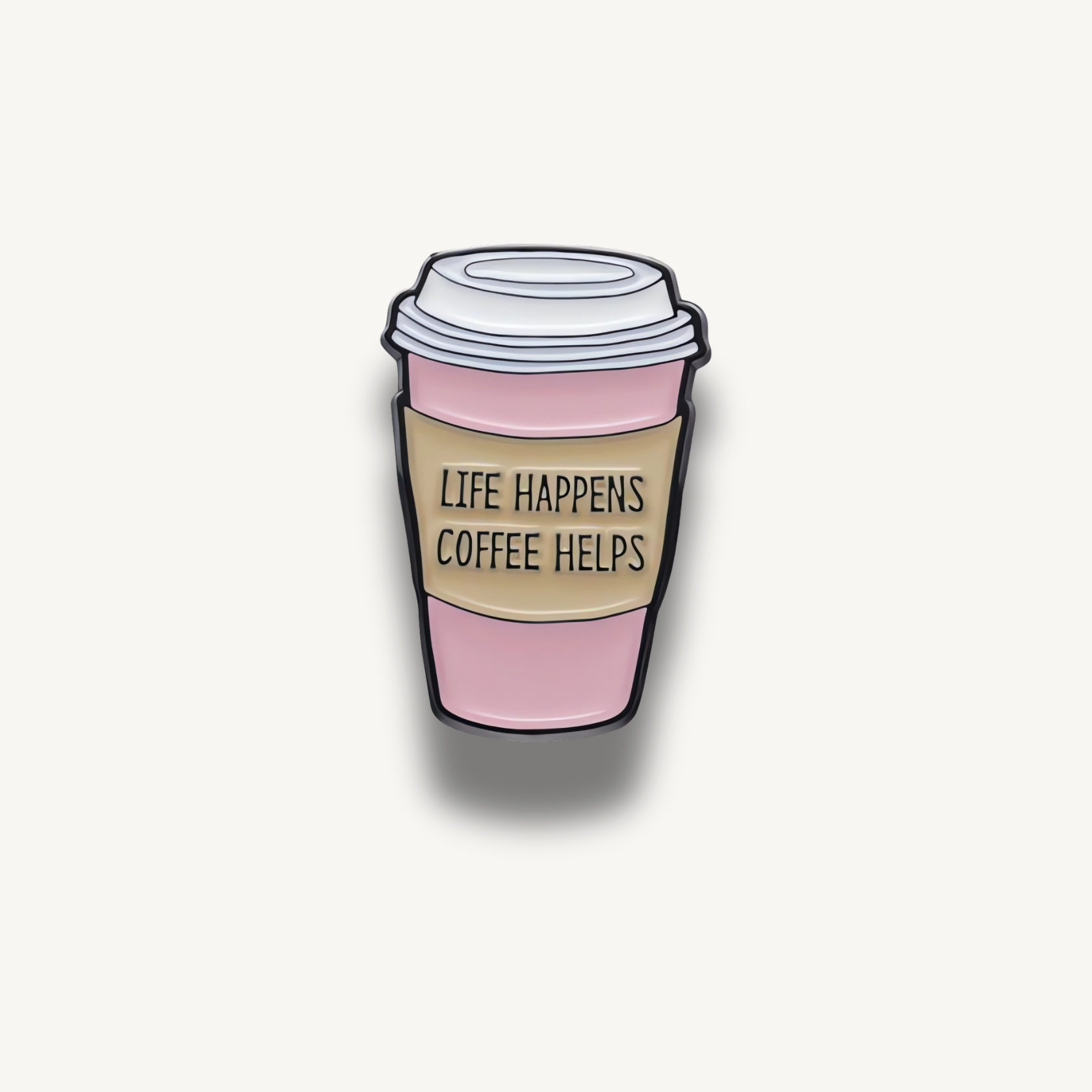 Brošňa v tvare ružového papierového pohára na kávu s bielym vrchnákom a hnedým obalom s textom 'LIFE HAPPENS COFFEE HELPS'.