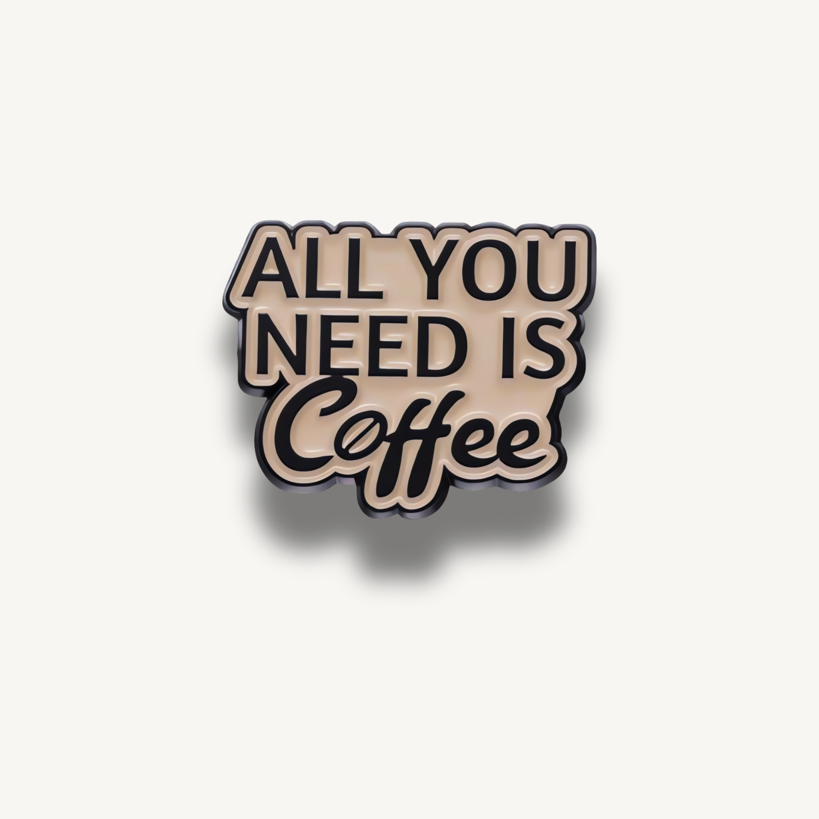 Brošňa s béžovým pozadím a čiernym nápisom 'ALL YOU NEED IS Coffee'.