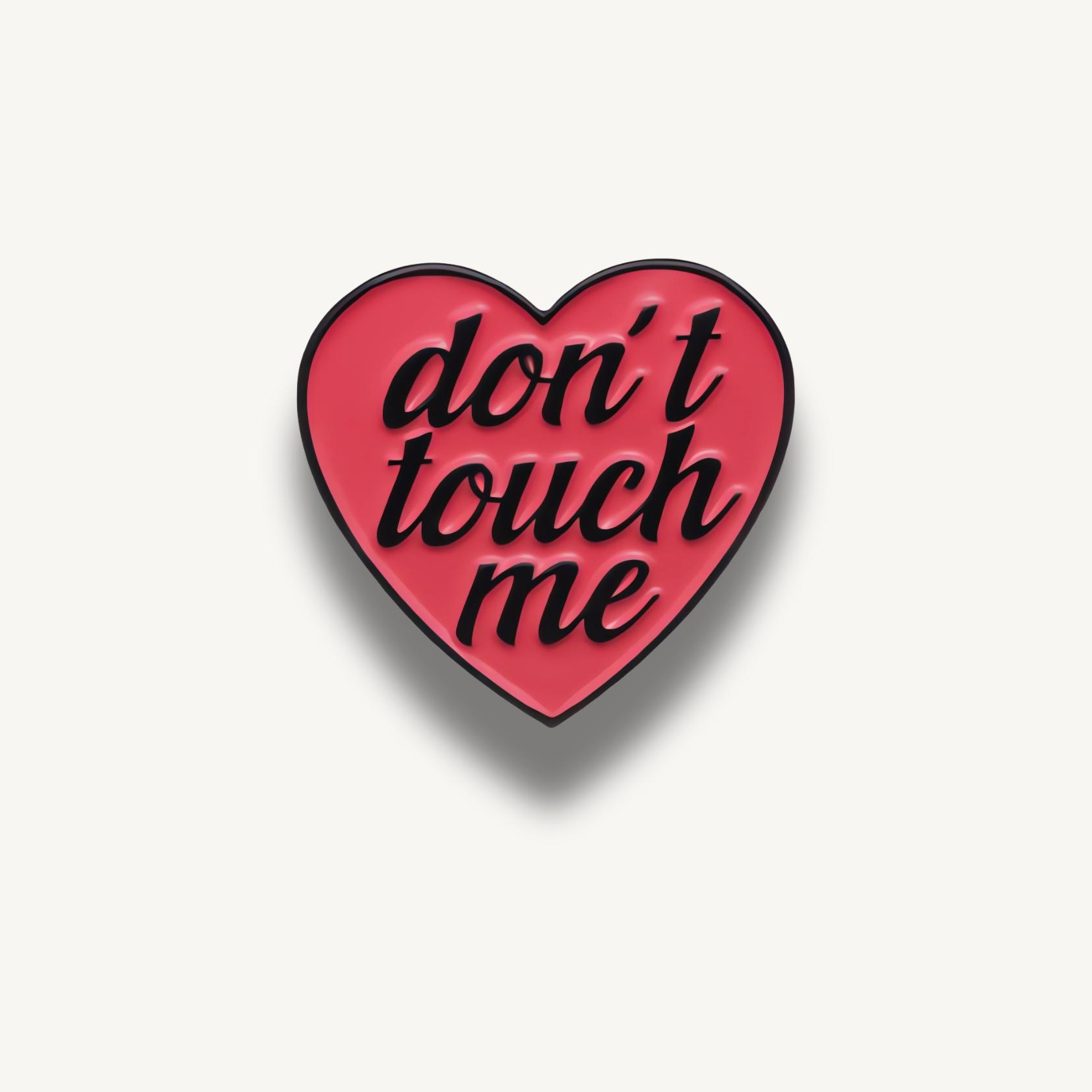 Ružová smaltovaná brošňa v tvare srdca s nápisom "don't touch me" čiernym písmom.