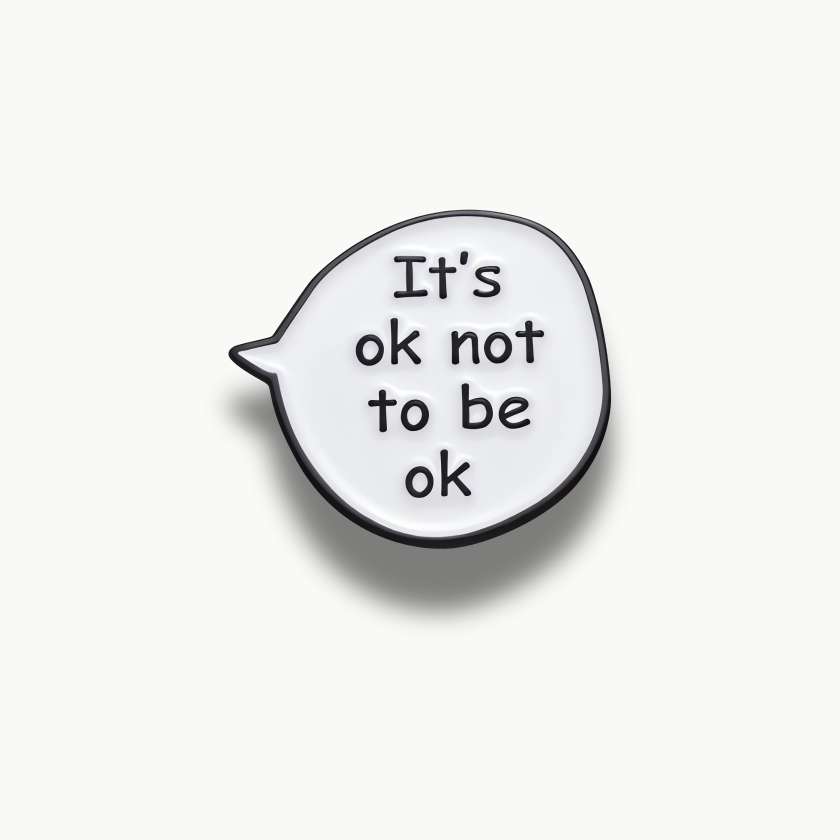 Biela smaltovaná brošňa v tvare rečovej bubliny s čiernym nápisom "It's ok not to be ok".