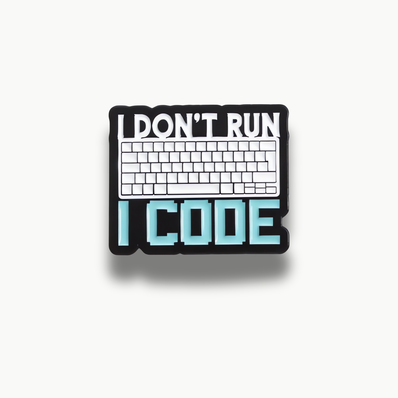 Čierna brošňa s bielou klávesnicou a nápisom 'I DON'T RUN I CODE'.