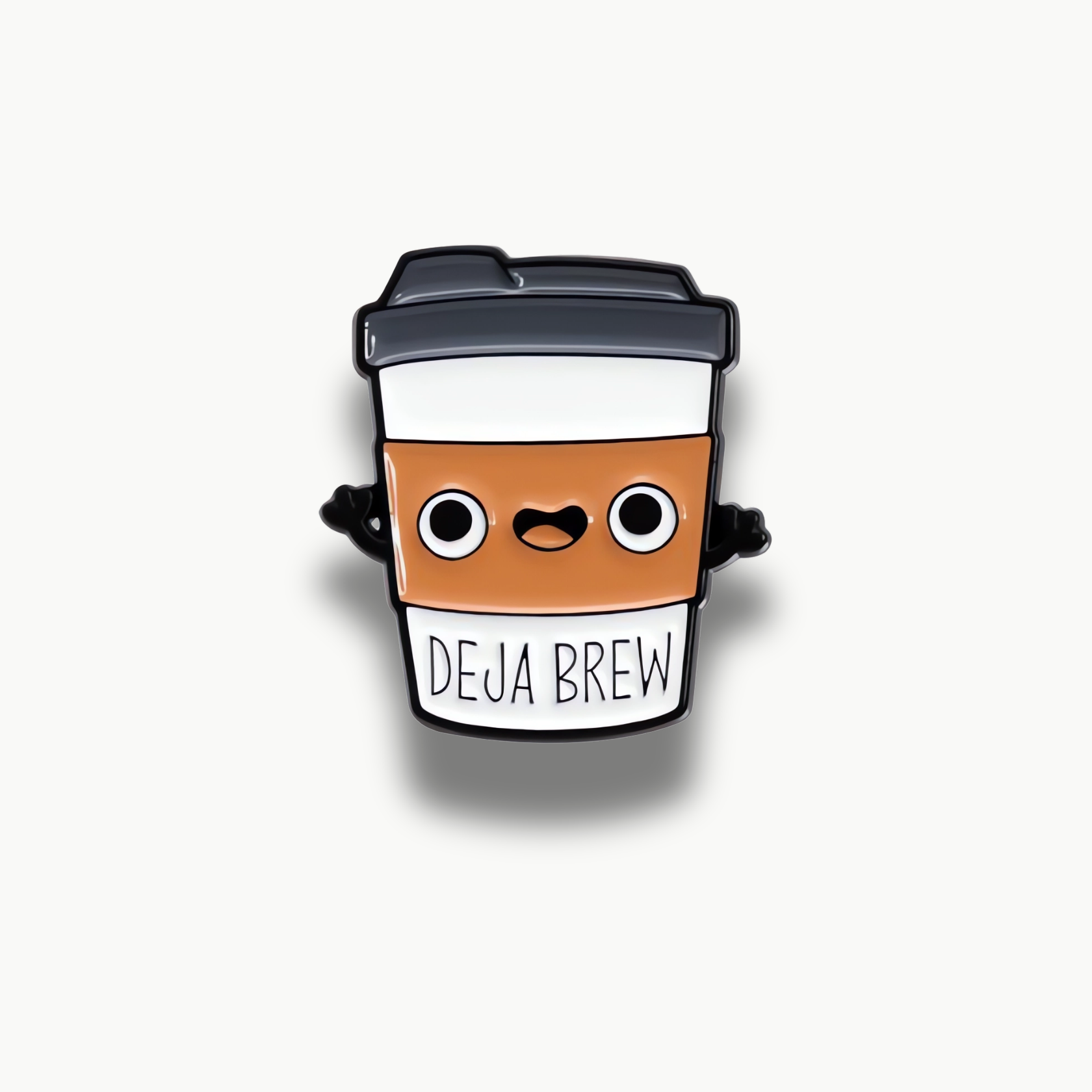 Smaltovaná brošňa v tvare bieleho kávového pohára s hnedou manžetou, veselou tváričkou a nápisom 'DEJA BREW'.