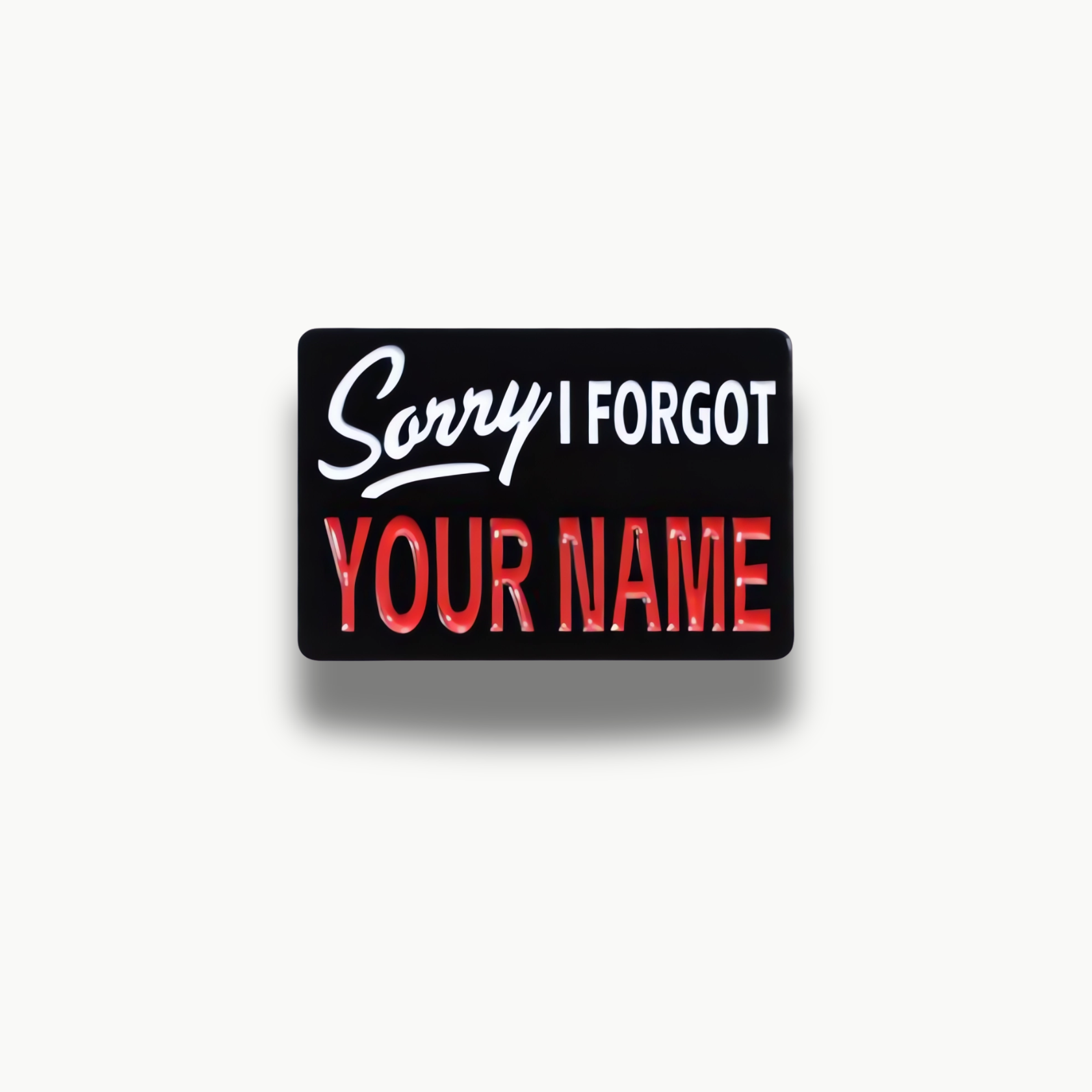 Čierna smaltovaná brošňa s bielym a červeným nápisom 'Sorry I Forgot Your Name'.