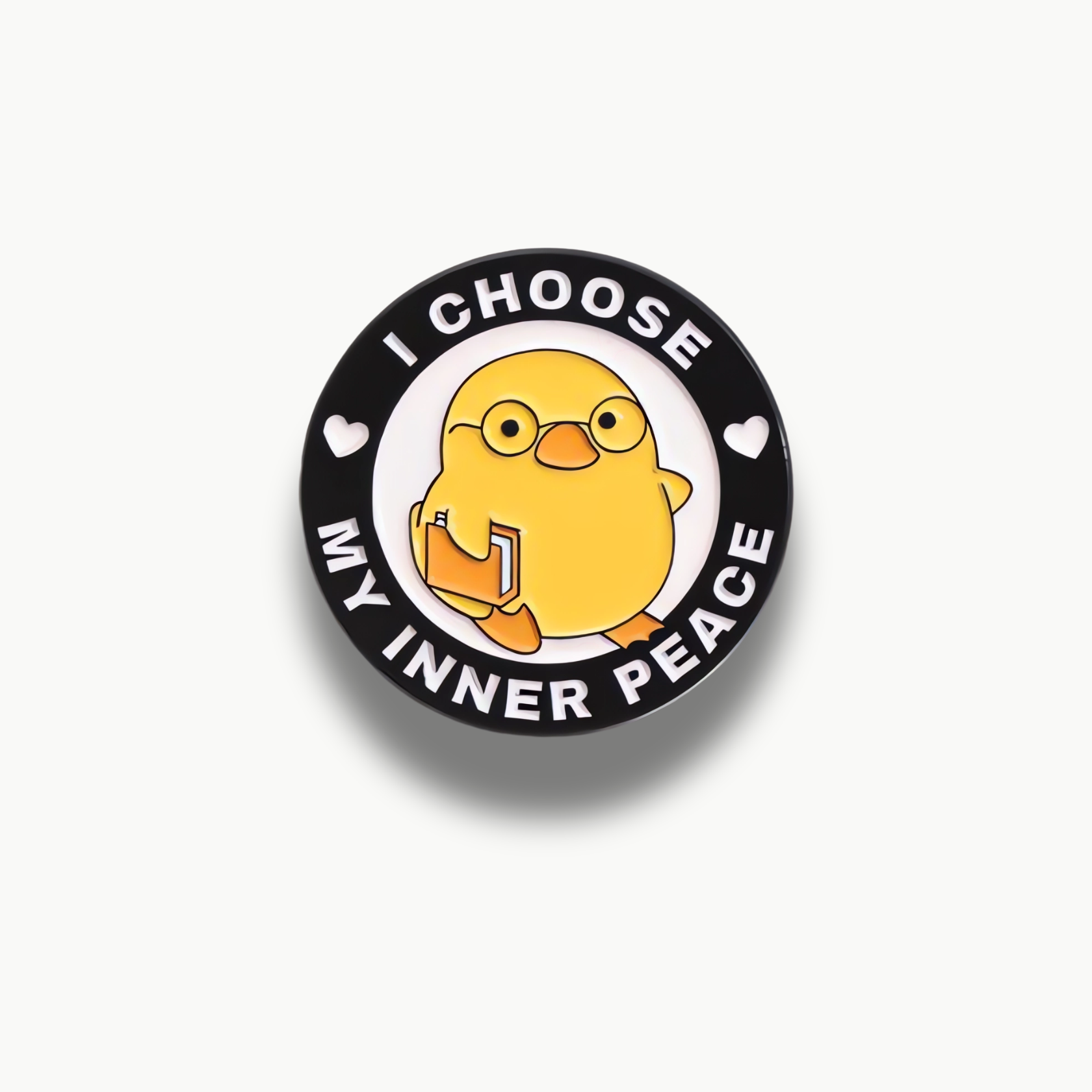 Okrúhla brošňa so žltým kuriatkom v okuliaroch držiace knihu, s textom "I CHOOSE MY INNER PEACE".