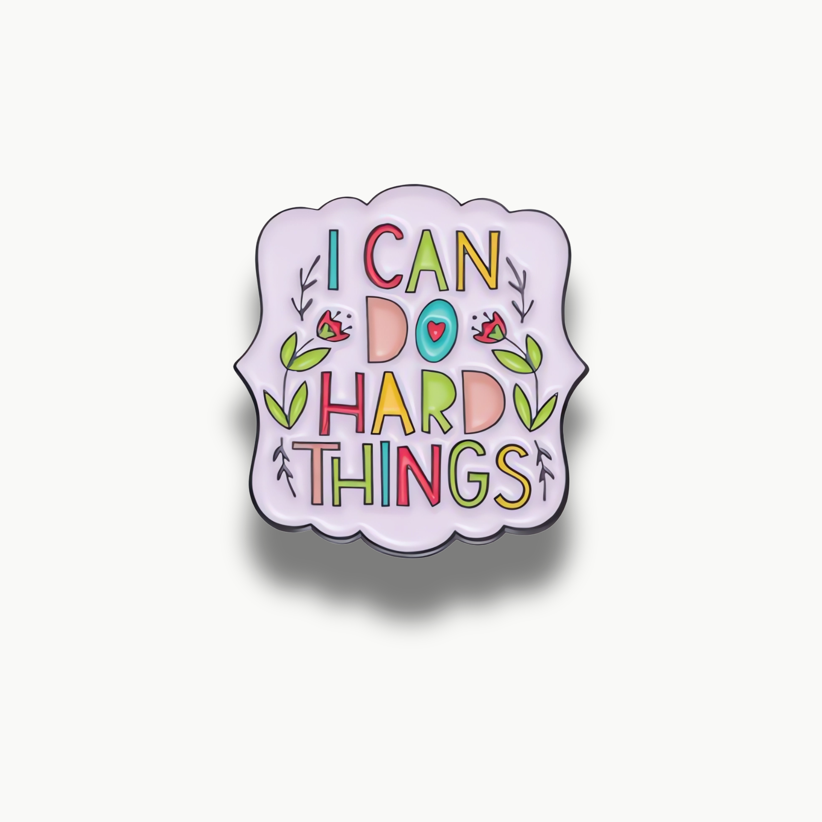 Svetlofialová brošňa s farebným nápisom "I CAN DO HARD THINGS" a kvetinovými detailmi.