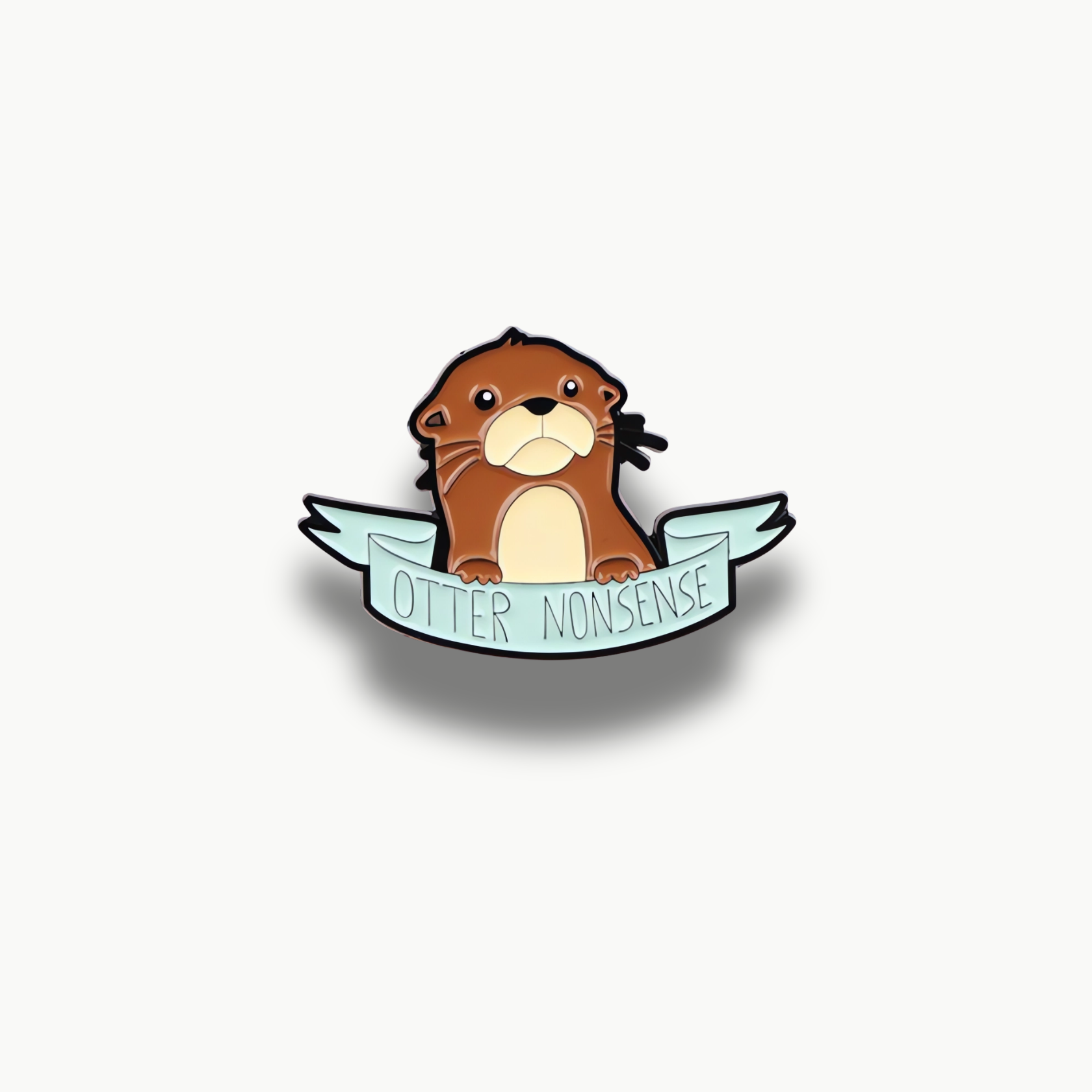 Hnedá kreslená brošňa v tvare vydry s modrou stuhou a nápisom Otter Nonsense.