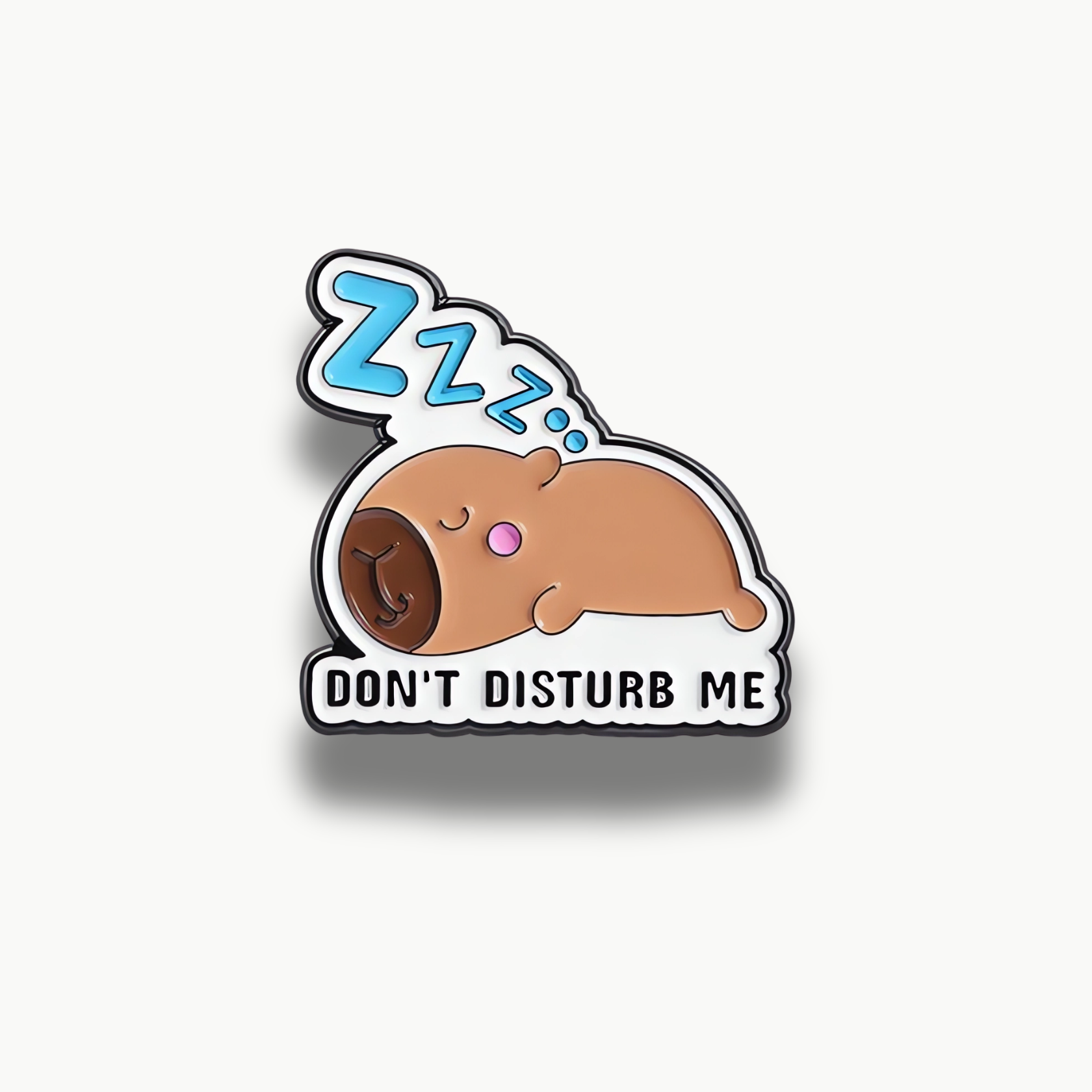 Brošňa so spiacou hnedou kapybarou a nápisom 'Don't Disturb Me'.