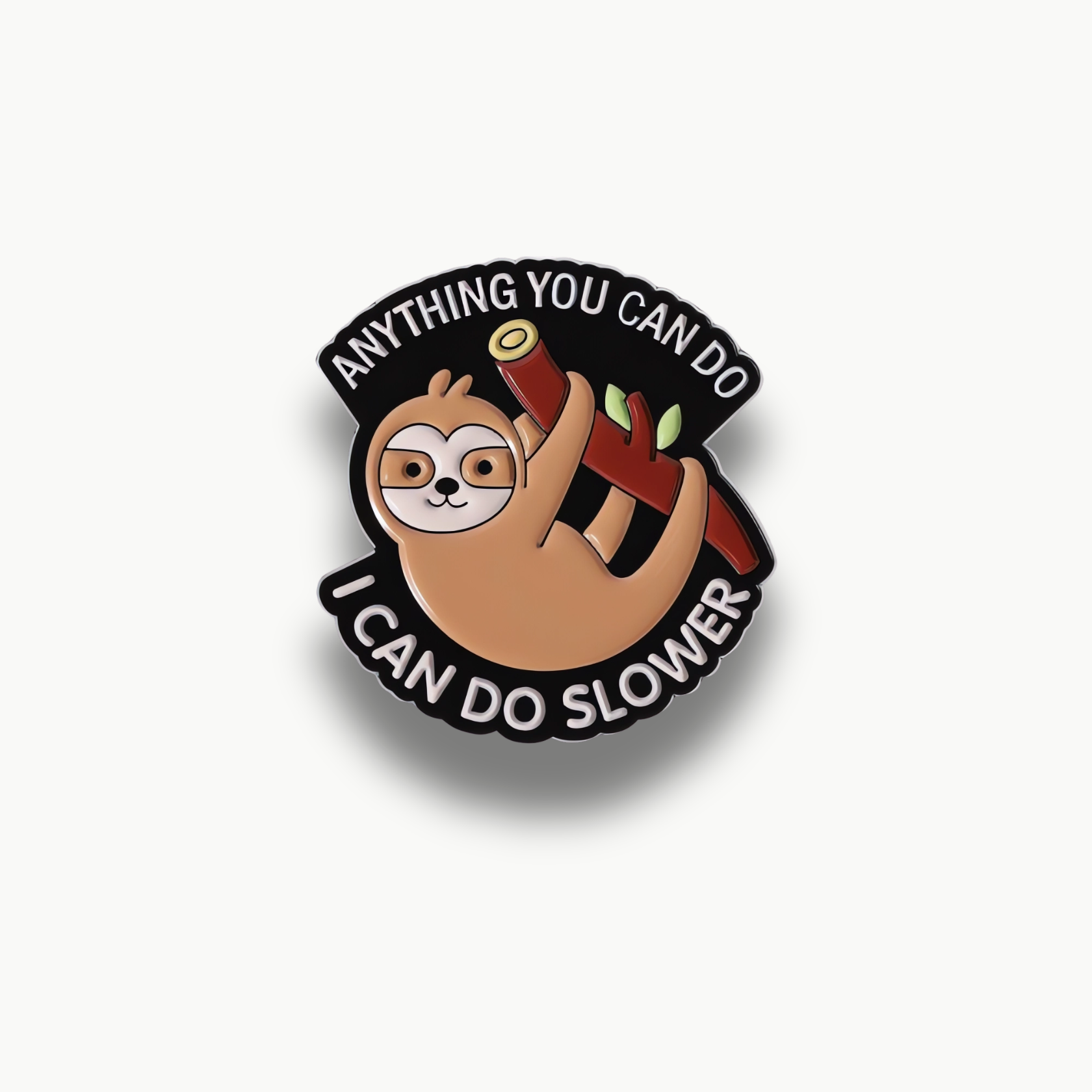 Smaltovaná brošňa s kresbou hnedého leňochoda visiaceho na červenom konári s čiernym pozadím a bielym textom 'ANYTHING YOU CAN DO I CAN DO SLOWER'.